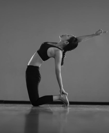 Woman in a graceful stretching pose, feeling calm and balanced.